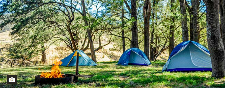 2 blue tents on the Capertee National Park campground with a fireplace burning in the foreground.