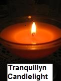 Red Burning candle in a cocktail glass with dark background. The candle is glowing and fluorescing the melting wax. The picture has a white label on the bottom with the word “Tranquillyn Candlelight”.